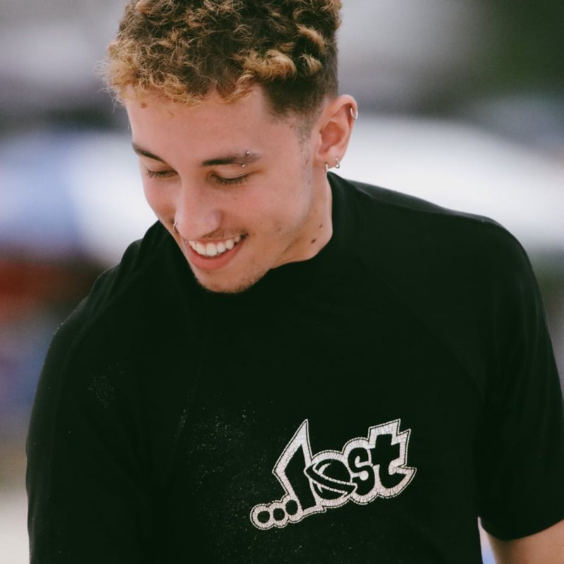 Otávio Minelli, filmmaker e designer, sorrindo de camiseta preta